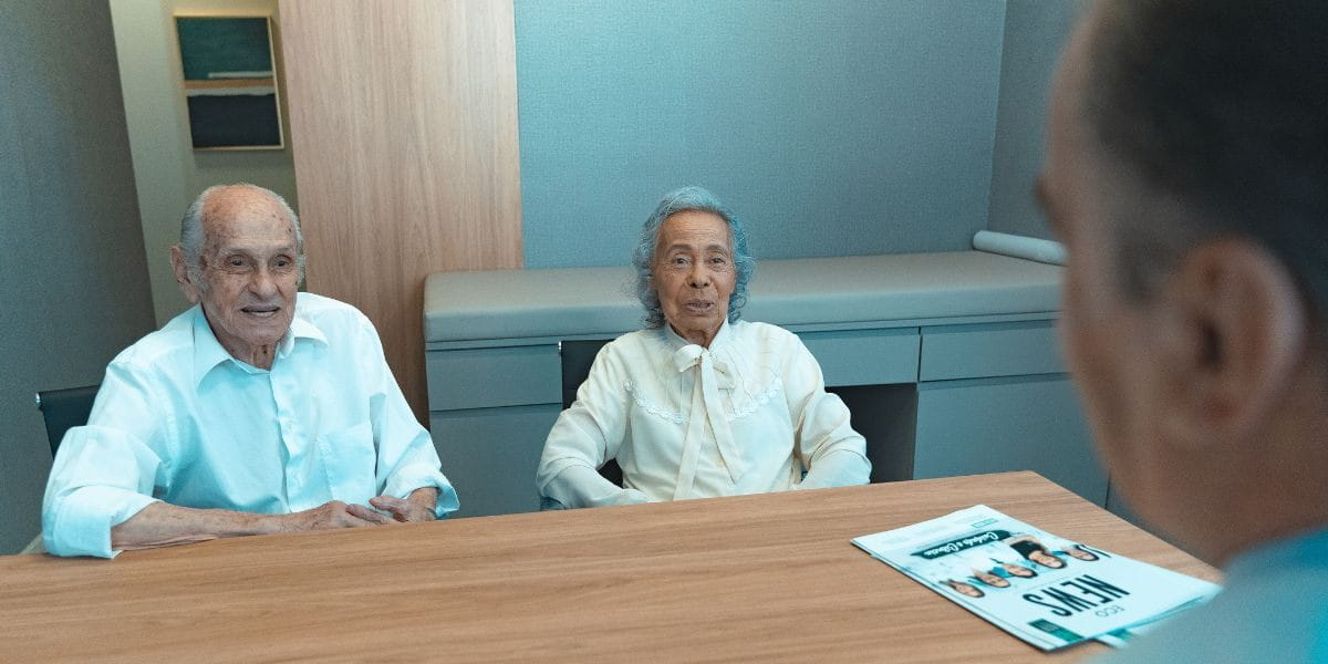 Casal de idosos em consulta com médico no Eco Medical Center, buscando cuidados para uma longevidade ativa e saudável